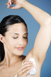 A young woman applying a de-odorant