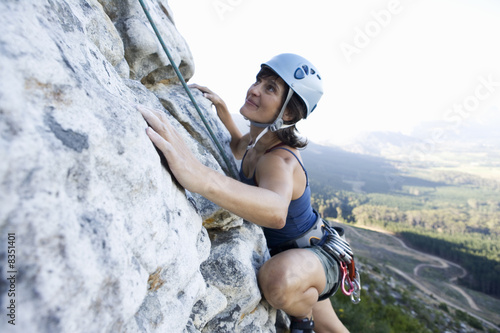 Photo: A climber climbing a rock face A climber climbing a rock face