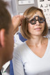 Optometrist in exam room with woman in chair