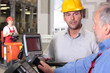 male engineer talking to forklift operator in warehouse