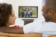 Couple in living room watching television smiling