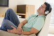 Man in living room listening to headphones sleeping Man in living room listening to headphones sleeping