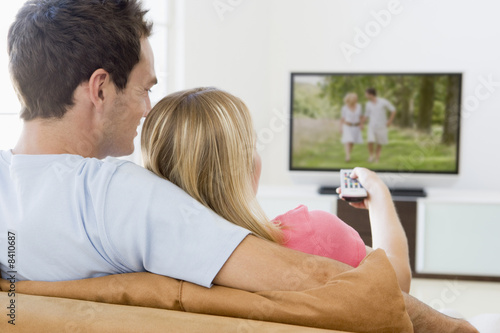 Couple in living room watching television