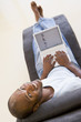 Man sitting in chair using laptop smiling