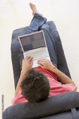 Photo: Man sitting in chair using laptop Man sitting in chair using laptop