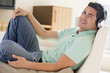 Man in living room listening to headphones smiling Man in living room listening to headphones smiling