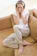 Woman in living room listening to headphones smiling