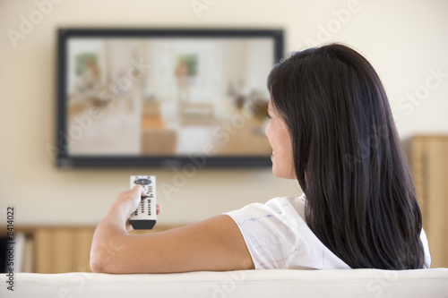 Photo: Woman in living room watching television Woman in living room watching television