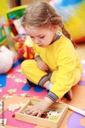 Foto: Cute child playing with puzzle Cute child playing with puzzle