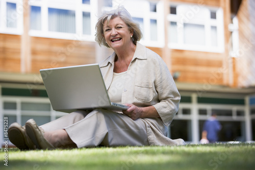Photo: Senior woman using laptop on campus Senior woman using laptop on campus
