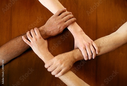 Foto: Four arms locked together at the wrists Four arms locked together at the wrists