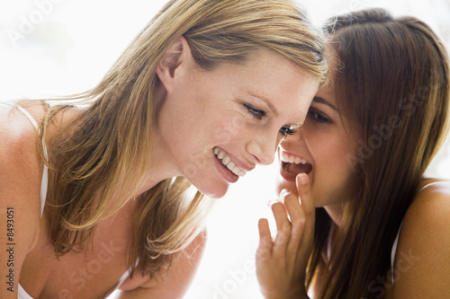 Photo: Two women whispering and smiling Two women whispering and smiling