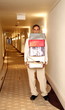 Bellboy carrying gift boxes down hallway