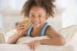 Young girl eating cookie in living room smiling Young girl eating cookie in living room smiling