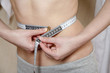 Woman measuring her waist