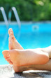Feet of a man relaxed at a swimming pool