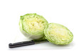 a head of iceberg lettuce, cut in half, with knife.