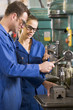 Two machinists working on machine