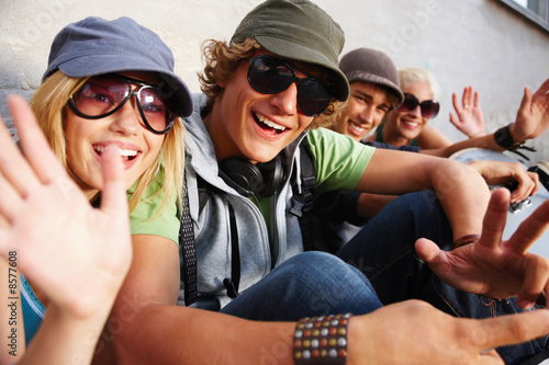 Young guys and girls sitting together and having fun