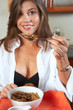 Sexy brunette eating breakfast