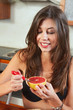 Sexy brunette eating breakfast