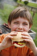 Little boy eating a hamburger
