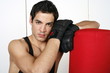 Young man leaning on punching bag