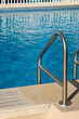 Ladder leading into an aqua blue pool