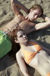 Photo: Young adult couple lying on beach Young adult couple lying on beach