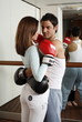 Young man and woman embracing in kickboxing class