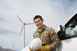 Engineer by car at wind farm, portrait