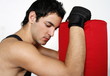 Young man leaning on punching bag