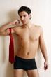 Bare chested young man posing with shorts and tie