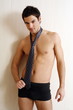Bare chested young man posing with shorts and tie