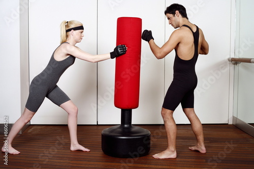 Photo: Young man and woman practicing with a punching bag Young man and woman practicing with a punching bag