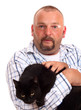 man holds black cat in hands