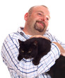 man holds black cat in hands