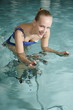 Young woman on exercise bike in spa pool