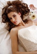 Bride lying down on wedding bed