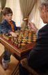 Mature man and little boy playing chess