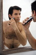 Man shaving in the bathroom mirror