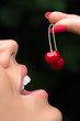 Foto: Lips of the girl tasting a cherry Lips of the girl tasting a cherry