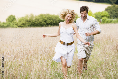 Photo: Couple running outdoors smiling Couple running outdoors smiling