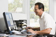 Man in home office at computer smiling