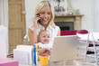 Photo: Mother and baby in home office with laptop and telephone Mother and baby in home office with laptop and telephone
