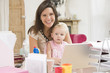 Photo: Mother and baby in home office with laptop Mother and baby in home office with laptop