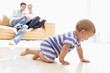 Couple in living room with baby smiling