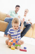 Photo: Couple in living room with baby smiling Couple in living room with baby smiling