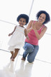 Photo: Mother and daughter indoors playing and smiling Mother and daughter indoors playing and smiling