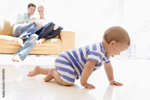 Photo: Couple in living room with baby smiling Couple in living room with baby smiling